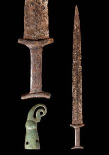 SCYTHIAN IRON SWORD WITH CROW-SHAPED BRONZE SCABBARD POINT: Ca. 550 - 500 BC. An iron sword with a long, tapering blade that terminates in a pointed tip, a rectangular grip with a lobed lower guard, and a pommel. The openwork scabbard tip is shaped like the he