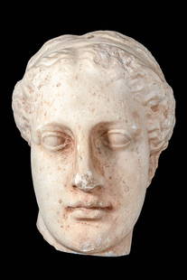 ROMAN MARBLE HEAD OF JUNO: Ca. AD 100 - 300. A Roman marble head of the goddess Juno, carved from fine-grained marble and inspired by late Classical Greek prototypes. The idealised features include a high forehead, almond-shape