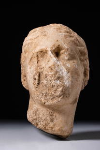GREEK HEAD OF APHRODITE: Ca. 300 - 1 BC. A marble head of a female figure, with softly contoured features and a broad, rounded face. The eyes are deeply set beneath a smooth brow. The hair is centrally parted and arranged in