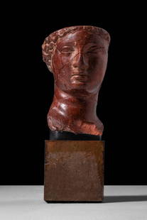 RARE ROMAN ROSSOANTICO MARBLE HEAD OF APHRODITE OF KNIDOS: Ca. AD 1 - 100. A finely carved head in Rosso Antico marble depicting a female deity. The face has soft, idealised features, including deeply set almond-shaped eyes, arched brows, and a full mouth wit