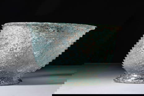SUPERB ROMAN BLUE GLASS BOWL ON PEDESTAL: Ca. AD 300. A translucent pale blue glass bowl with a rounded body that tapers towards a flared pedestal base. The broad rim is everted, and a double horizontal groove encircles the upper exterior wal