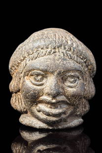ROMAN POTTERY WHISTLE IN THE FORM OF A THEATRE MASK: Egypt, mid-Ptolemaic to Romano-Egyptian Period, Ca. 150 BC – AD 300. A mould-made pottery whistle modelled as a grotesque theatrical mask. The face is rounded with exaggerated features, including ar