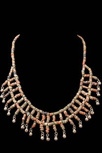 EGYPTIAN FAIENCE NECKLACE WITH STONE AND FAIENCE BEADS: Late Period to Ptolemaic, Ca. 664 - 30 BC. A restrung necklace composed of faience annular beads in a variety of earthy tones, including green, red, and beige. The design consists of a central strand