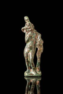 ROMANO-EGYPTIAN BRONZE FIGURINE OF HARPOCRATES: Ca. 30 BC - 200 BC. A bronze figurine of nude Harpocrates standing with his weight shifted to the right leg. His right hand is raised to the lips, and the left arm cradles a cornucopia extending downw