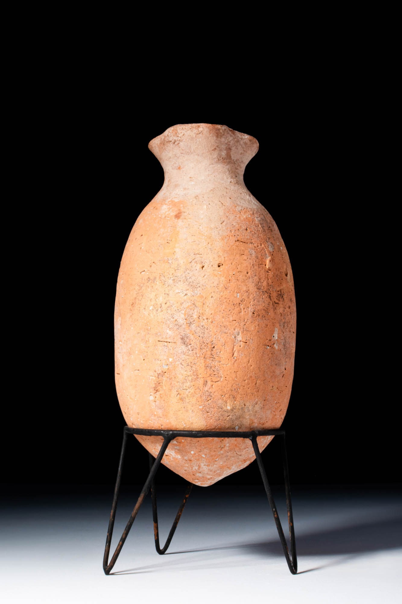 CYPRIOT BRONZE AGE JUG: Ca. 2000 - 1000 BC. A tall pottery vessel with an ovoid body tapering to a pointed base, a narrow neck with a flaring rim, and a single loop handle joining the shoulder to the rim. Size: 160mm x 80mm;