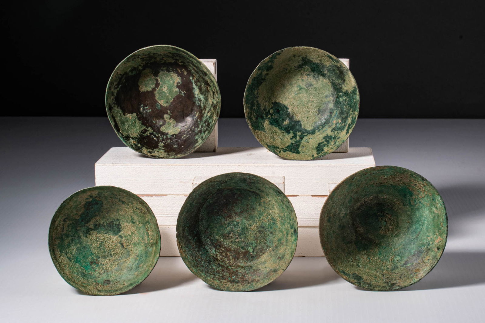 COLLECTION OF ETRUSCAN BRONZE BOWLS: Ca. 400 - 200 BC. A collection of five hammered bronze bowls, displaying a range of profiles including flaring forms with flat bases and hemispherical examples with rounded bottoms. For similar see: M