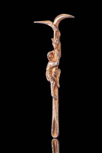 ROMAN SILVER-GILT SURGICAL TOOL WITH FIGURAL HANDLE: Ca. AD 100 - 200. A silver-gilt medical implement with a long, tapering shaft terminating in a small tear-shaped spoon at one end and a bifurcated tip at the other. The handle is modelled with a male