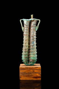 ROMAN GLASS DOUBLE UNGUENTARIUM: Ca. AD 200 - 300. A glass double unguentarium composed of two elongated, cylindrical vials fused along their length. Each chamber tapers slightly towards the rounded base and is encircled by a