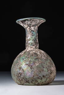ROMAN GLASS PEAR-SHAPED UNGUENTARIUM: Ca. AD 1 - 200. A translucent pale green glass unguentarium with a pear-shaped body that curves into a concave base. The tall neck rises into a wide, outward-flaring rim. For similar see: The Cesnola