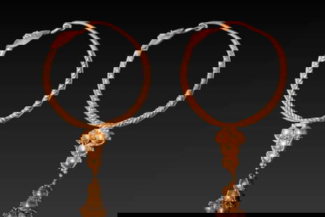 PAIR OF ROMAN HIGH KARAT GOLD EARRINGS WITH GOLD PELLETS: Ca. AD 1 - 300. A pair of gold earrings, each composed of a twisted wire hoop tapering towards a plain looped catch. The opposite end terminates in a slightly domed circular plate decorated with