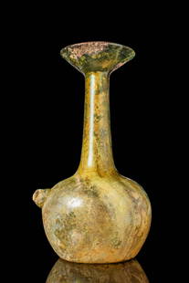 ROMAN GLASS POURER FLASK: Ca. AD 100 - 200. A glass pourer flask with a domed body and a tall, slender neck that expands into a wide, flaring rim. A small, protruding spout is positioned on the shoulder. The vessel rests on a