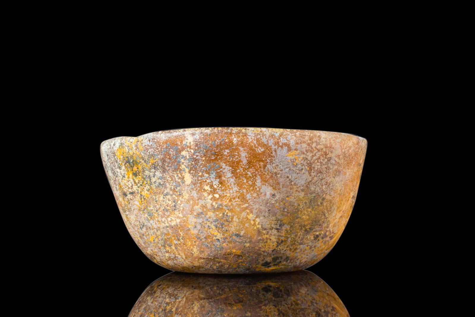 ROMAN GLASS BOWL: Ca. AD 100 - 300. A glass bowl with a deep, rounded body and a slightly uneven rim. The vessel is free-blown, with a gently curving profile tapering towards a flat base. For similar see: Lightfoot Ch.