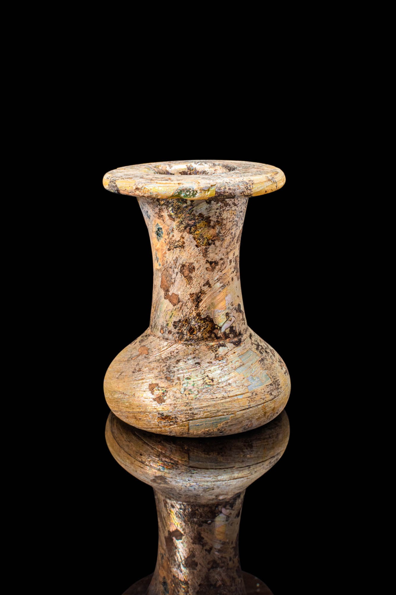 ROMAN GLASS UNGUENTARIUM: Ca. AD 100 - 200. A glass unguentarium with a spindle-shaped body. The sloping sides rise to a narrow neck that expands into a broad mouth with a rounded edge. For similar see: The Metropolitan Museum