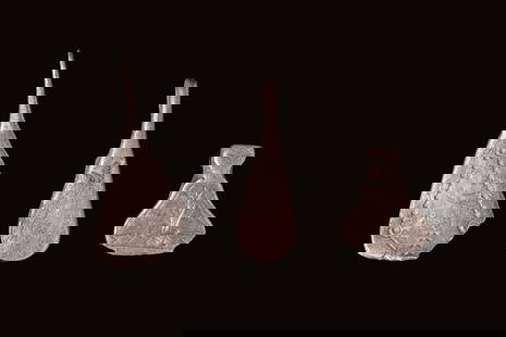 SET OF VIKING SILVER AXE-SHAPED PENDANTS: Ca. AD 800 - 1000. A set of three silver axe-shaped pendants, each with a suspension loop at the top. All pendants share a tapered form that widens towards the base, with variations in proportions and