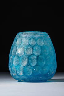 OUTSTANDING SASANIAN CUT GLASS CUP: Ca. AD 400 - 600. A semi-translucent turquoise cut glass cup with a convex base, tall body tapering towards the opening with a straight rim. The exterior is decorated with a honeycomb pattern of deepl