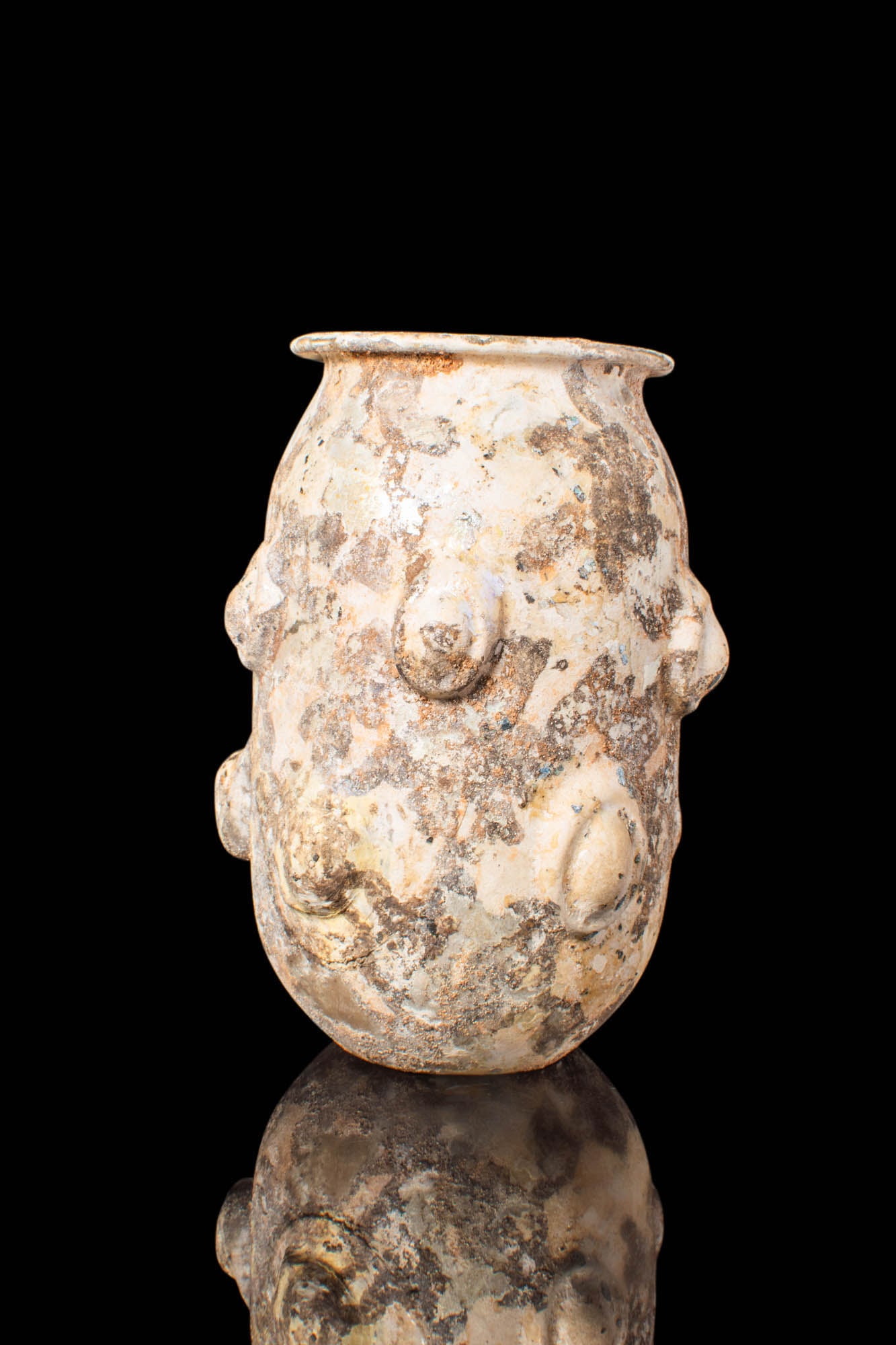 ABBASID UNGUENTARIUM WITH PROTRUDING KNOTS: Ca. AD 600 - 800. A glass unguentarium featuring a tubular body seated on a petite, round base, and a large neck with an outward-flared rim. The body is adorned with two registers of protruding knots.