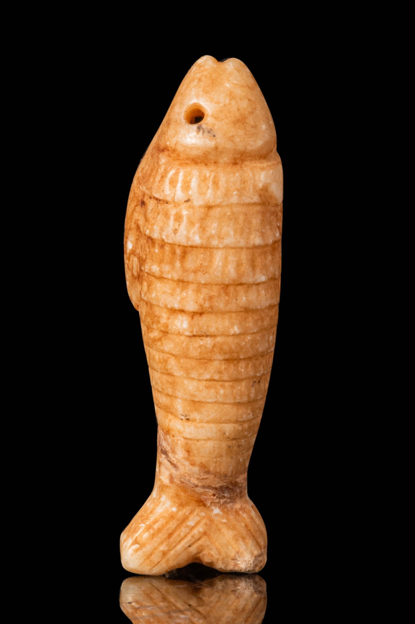 MESOPOTAMIAN FAWN STONE FISH AMULET WITH ORIGINAL PROF. LAMBERT REPORT: Ca. 1000 - 300 BC. A fawn stone amulet in the shape of a fish with a rounded upper surface and a flat back. The body is carved with a series of incised scales arranged in a regular pattern. The head i