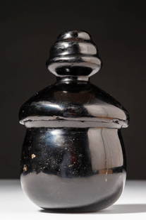 MIXTEC OBSIDIAN LIDDED JAR: Ca. AD 1200 - 1500. A hand-carved jar from smoky grey obsidian with a globular body, a thick flared rim, and a deep inner basin. The bell-shaped lid is topped with a tiered, beehive-shaped handle. Siz