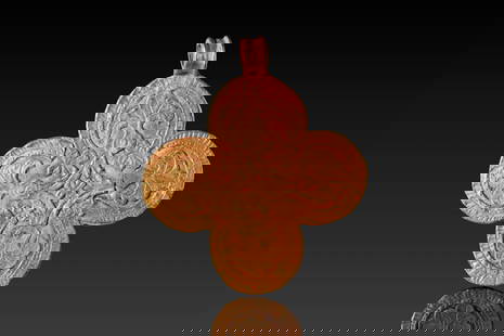 BYZANTINE HIGH KARAT GOLD CROSS PENDANT WITH PALM BRANCHES: Ca. AD 600 - 800. A gold cross pendant formed of four joined circular lobes. The front is decorated with a symmetrical design of stylised palmettes and foliate scrolls arranged around a central cross