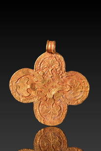 BYZANTINE HIGH KARAT GOLD CROSS PENDANT WITH PALM BRANCHES: Ca. AD 600 - 800. A gold cross pendant with four rounded arms forming a clover-like shape. Each arm is decorated with a palm branch motif enclosed within a hatched border, with additional foliate and