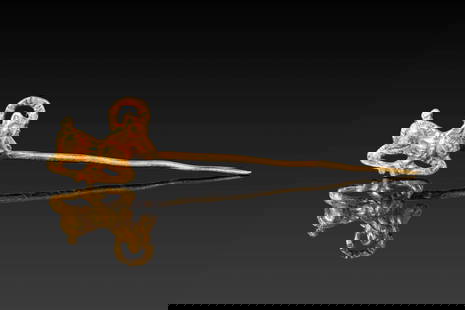 STUNNING SCYTHIAN HIGH KARAT GOLD PIN WITH IBEX: Ca. 500 - 300 BC. A tapering gold pin with a finial in the form of a recumbent ibex, its limbs folded beneath the body and horns curving backwards. The surface is detailed with incised grooves