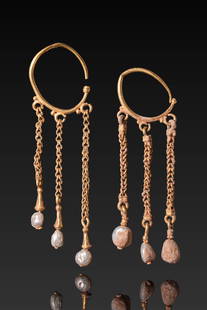 MATCHED PAIR OF BYZANTINE HIGH KARAT GOLD AND PEARL EARRINGS: Ca. AD 400 - 600. A matched pair of gold earrings, each formed from a crescent-shaped hoop supporting three suspended chains. Each chain is composed of twisted links terminating in a conical gold