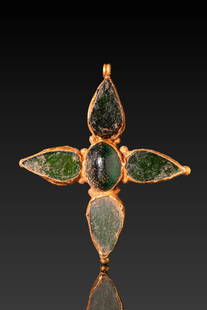 FRANKISH HIGH KARAT GOLD CROSS WITH GREEN GLASS CABOCHONS AND MONOGRAM: Ca. AD 600 - 800. A gold cross composed of a central oval cell flanked by four symmetrically arranged teardrop-shaped arms, each set with a green glass cabochon. The reverse is decorated with incised