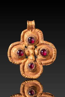 BYZANTINE HIGH KARAT GOLD CROSS PENDANT WITH RED GARNET CABOCHONS: Ca . AD 600 . A 20.5 kt gold cross pendant formed of four rounded lobes, each set with a garnet cabochon within a circular beaded collet. The lobes are outlined with a ridged border and joined by a