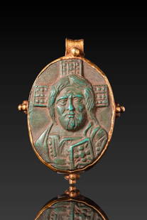 BYZANTINE HIGH KARAT GOLD PENDANT WITH CAMEO DEPICTING CHRIST: Ca. AD 800 - 1000. An oval pendant with a raised image of Christ Pantocrator, shown frontally with a nimbate cross behind the head, holding a Gospel book in his left hand. The image is enclosed