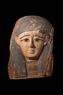 LARGE EGYPTIAN PAINTED SARCOPHAGUS PANEL WITH MASK: Late Period to Ptolemaic Period, Ca. 664 - 30 BC. A carved wooden sarcophagus panel with a mask with painted detail, depicting a stylised face with large, almond-shaped eyes outlined in black, arched