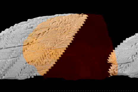 EGYPTIAN SANDSTONE RELIEF DEPICTING AN OFFERING SCENE: New Kingdom, Ca. 1213 - 1203 BC. Fragment of a sandstone sunk-relief depicting the pharaoh Akhenaten under the rays of the sun god Aten, in front of an altar laden with offerings while he raises an