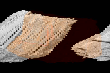 FRAGMENT OF A SUNK RELIEF DEPICTING THE PHARAOH AKHENATEN ADORING THE SOLAR DISC ATEN: New Kingdom, Ca. 1353 - 1336 BC. A limestone relief fragment carved with vertical columns, including two cartouches containing the throne name of Akhenaton. Traces of red pigment remain within the