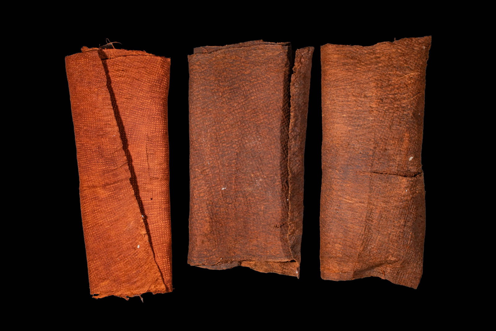 GROUP OF TAPA CLOTH: Ca. 20th century AD. A group of three barkcloths (tapa), each beaten and felted from inner mulberry bark and naturally dyed in varying reddish-brown tones. Tapa cloths were central to ceremonial and s