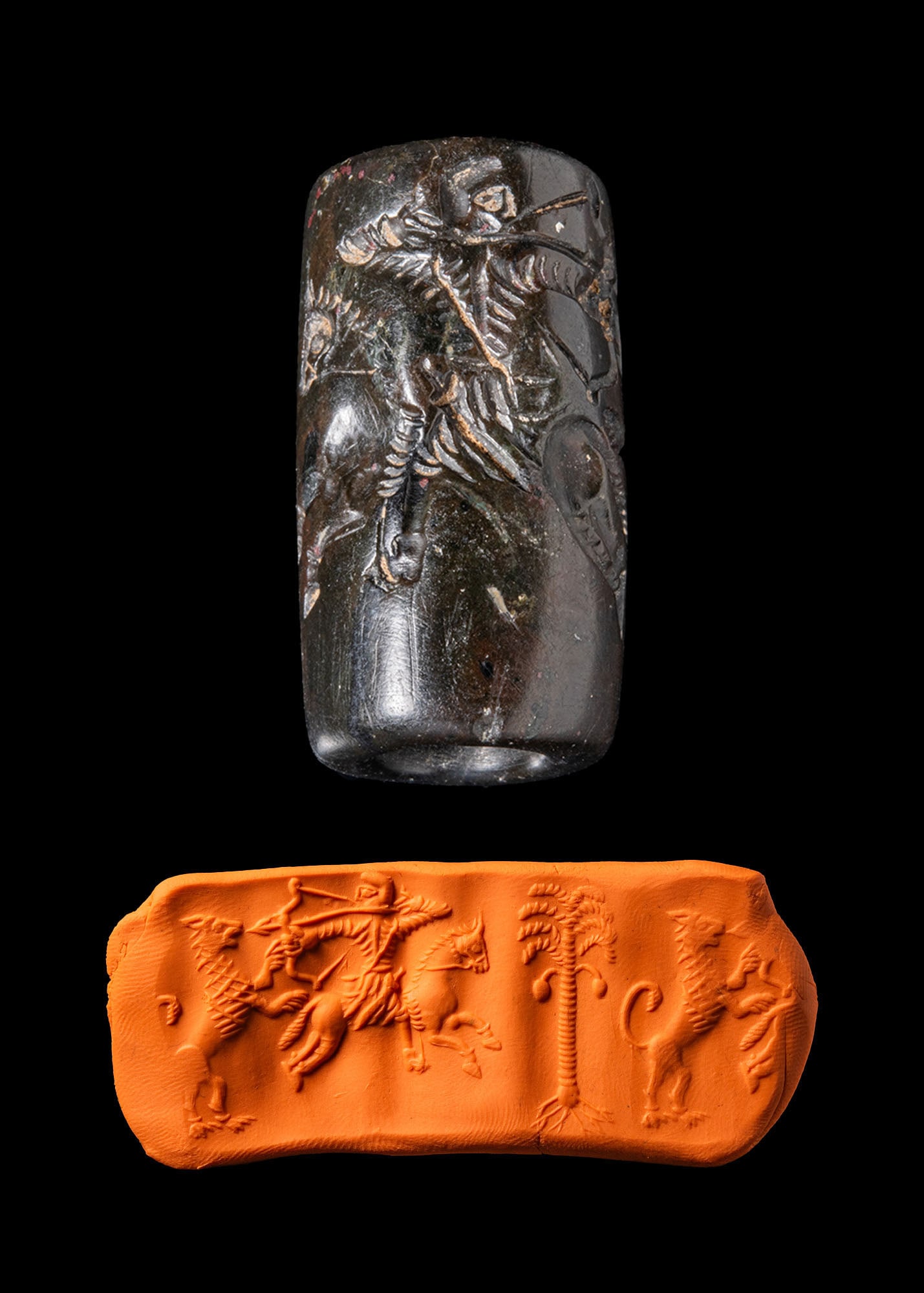 PARTHIAN HEAMATITE CYLINDER SEAL WIHT HUNTER ON HORSE: Ca. 5th - 4th century BC or later. A hardstone cylinder seal engraved with a hunter on horseback drawing a bow at a lion, a date palm in the exergue.Size: 32mm x 17mm; Weight: 13gProvenance: Private L