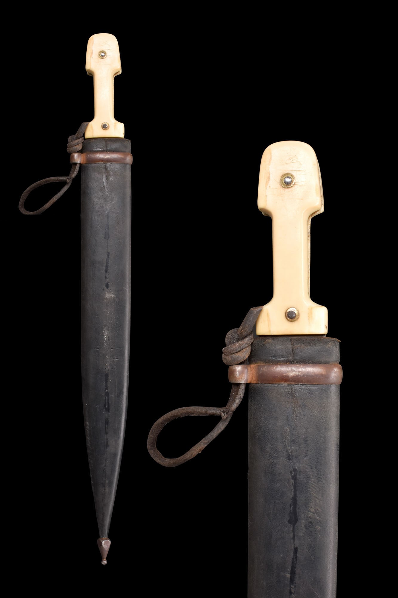 CAUCASIAN STEEL DAGGER (KINDJAL) WITH LEATHER SCABBARD: Ca. 1330H (AD 1911). A steel dagger commonly referred to as a kindjal. Whilst the bone handle is of a type commonly found in the Caucasus, the blade bears an Arabic makers mark. As such, this item is