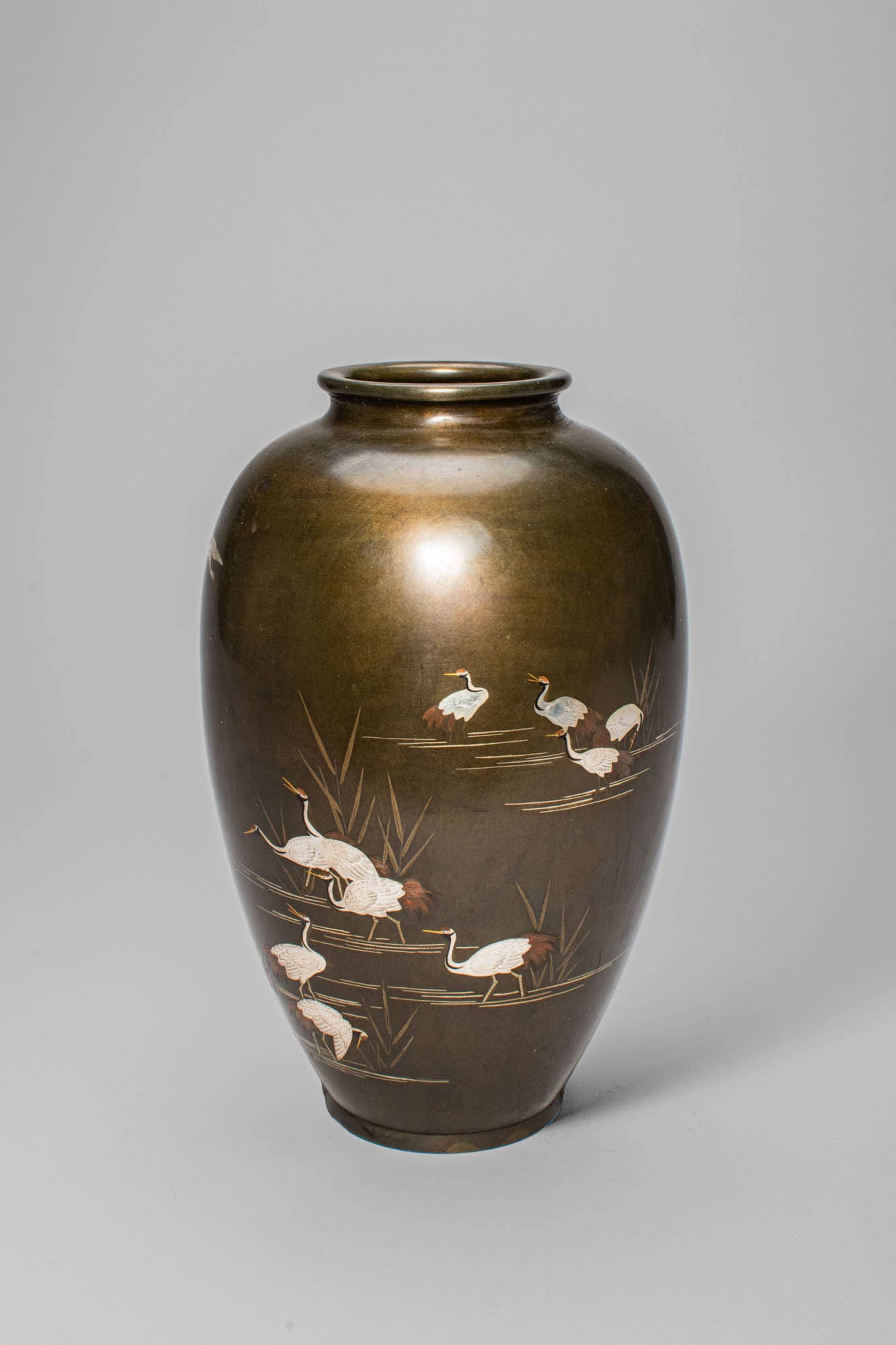 JAPANESE BRONZE VASE WITH INLAY DEPICTING CRANES: Meiji Period, Ca. late 19th - early 20th century AD. A beautiful bronze vase of ovoid form, finely inlaid with a serene scene of cranes wading in shallow water among reeds. The birds, symbolising long