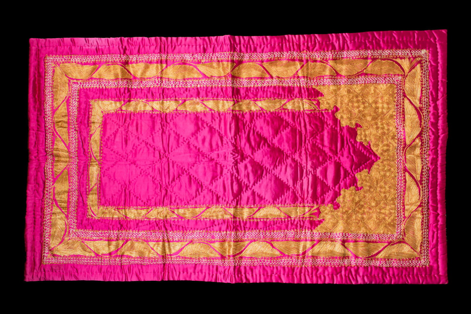 OTTOMAN SILK HANGING PANEL WITH MIHRAB: Ca. 19th - 20th century AD. A hanging panel with a tall cusped mihrab in couched gold-metal thread. The rectangular panel is quilted over soft wadding and finished with mitred borders.Size: 1420mm x 8