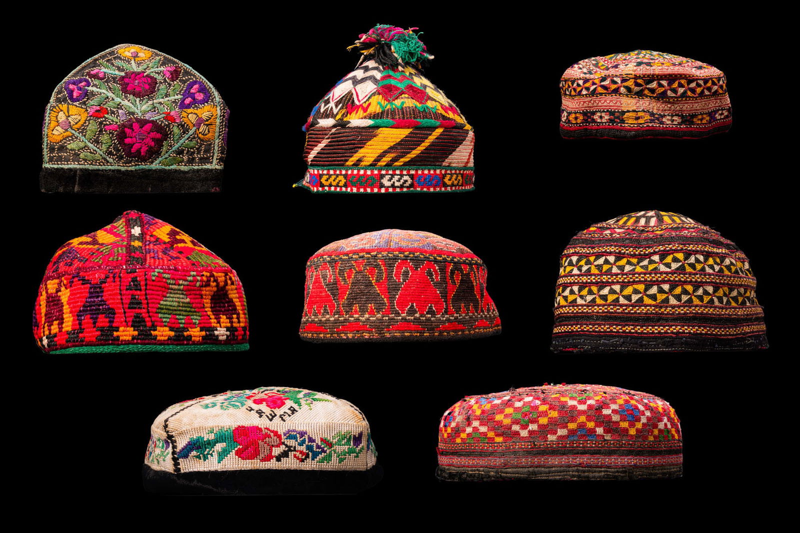 COLLECTION OF POLYCHROME FABRIC CAPS: Ca. 19th - 20th century AD. A collection of eight polychrome textile caps, each domed or conical and panelled, one with a tasselled apex. Decorated in coloured threads with geometric and floral motifs