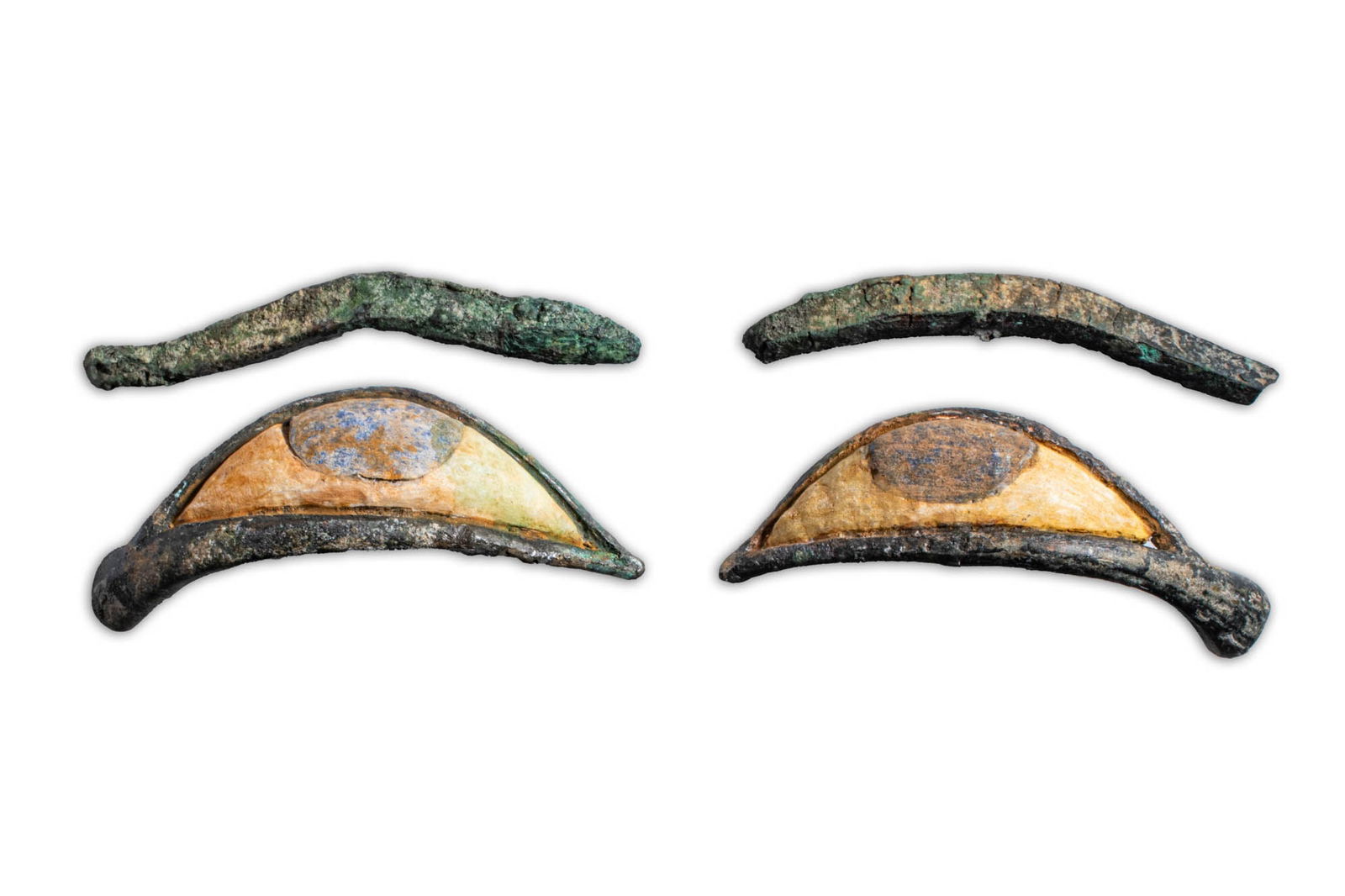 PAIR OF EGYPTIAN EYE INALYS AND EYEBROWS: Late Period, Ca. 664 - 30 BC. A pair of eye inlays and separate bronze eyebrows. Each eye inlay is shaped with an elongated contour and inset with a white sclera and a blue iris. The corresponding cur