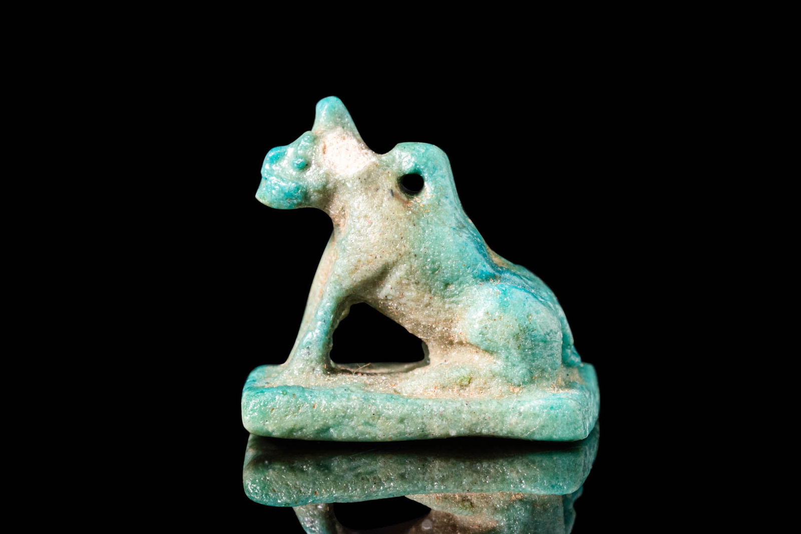 EGYPTIAN FAIENCE SPHINX-SHAPED DEITY: Late Period - Ptolemaic Period, Ca. 664 - 30 BC. A faience amulet modelled in the form of a sphinx, seated on an integral rectangular base, with a loop for suspension at the back. Reviewed by Simone M