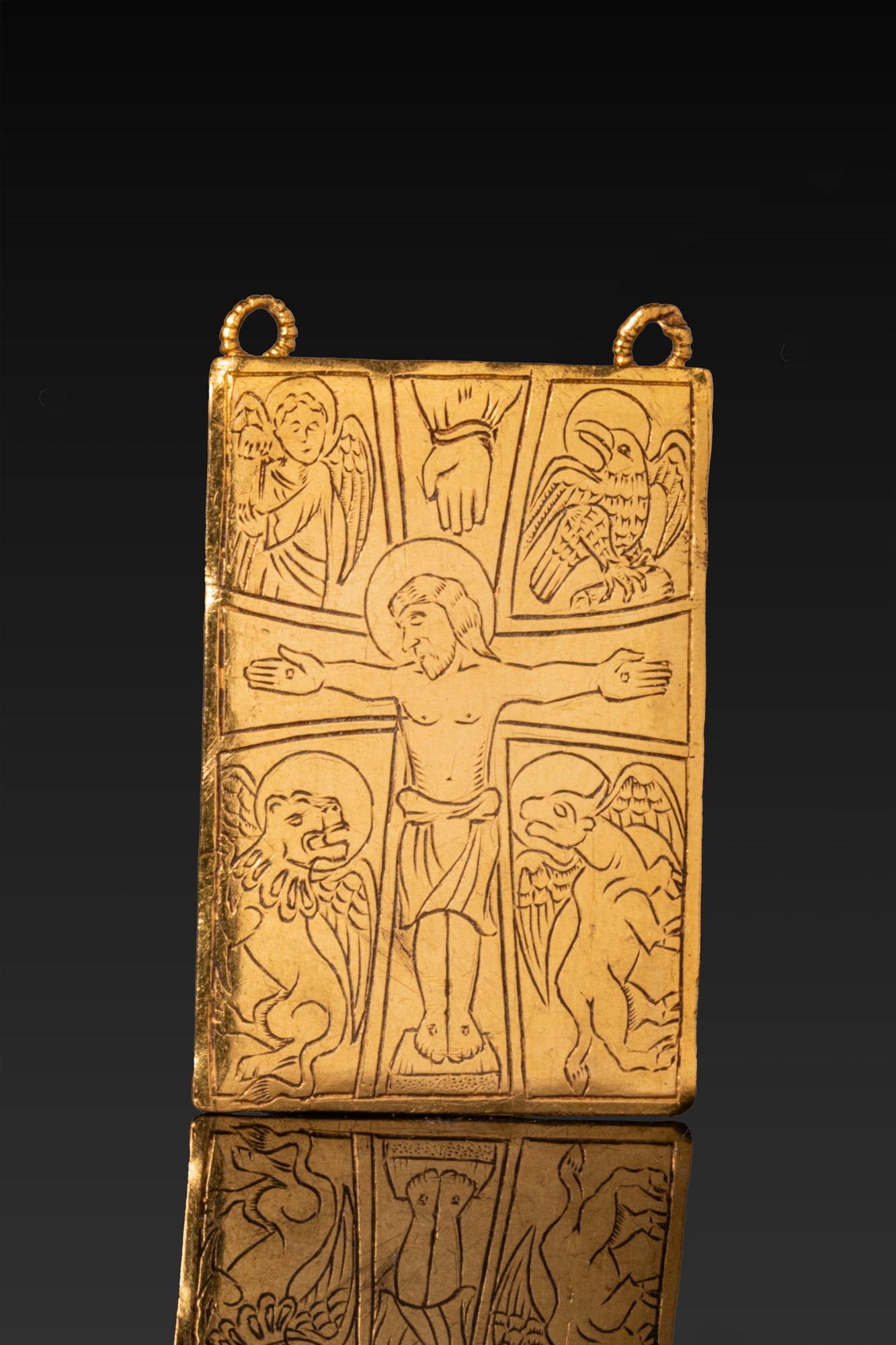 MEDIEVAL HIGH KARAT GOLD AND ROCK CRYSTAL RELIQUARY PENDANT WITH CRUCIFIXION: Ca. AD 1300 - 1500 A rectangular gold reliquary pendant with a flat front plate and an inset crystal panel at the reverse, the upper edge fitted with two small suspension loops. The obverse is engrave