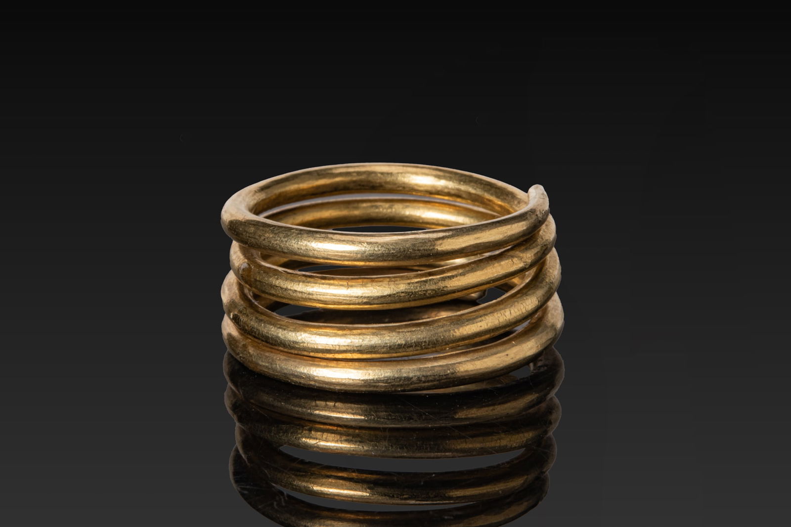 HEAVY CELTIC HIGH KARAT GOLD HAIR RING: Ca. 300 - 100 BC A gold hair ring formed from a solid round-section wire coiled into a tight spiral of four turns. Size: D:18.75mm / US: 8 3/4 / UK: R; Weight: 17g. Provenance: Private London collecti