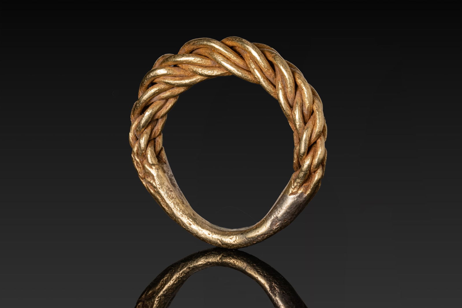 HUGE VIKING HIGH KARAT GOLD TWISTED RING: Ca. AD 900 - 1100 A gold ring composed of a rounded plain hoop, from which on each side single round-section strands diverge and are tightly braided into a thick plait. Size: D:19.35mm / US: 9 1/2 / U