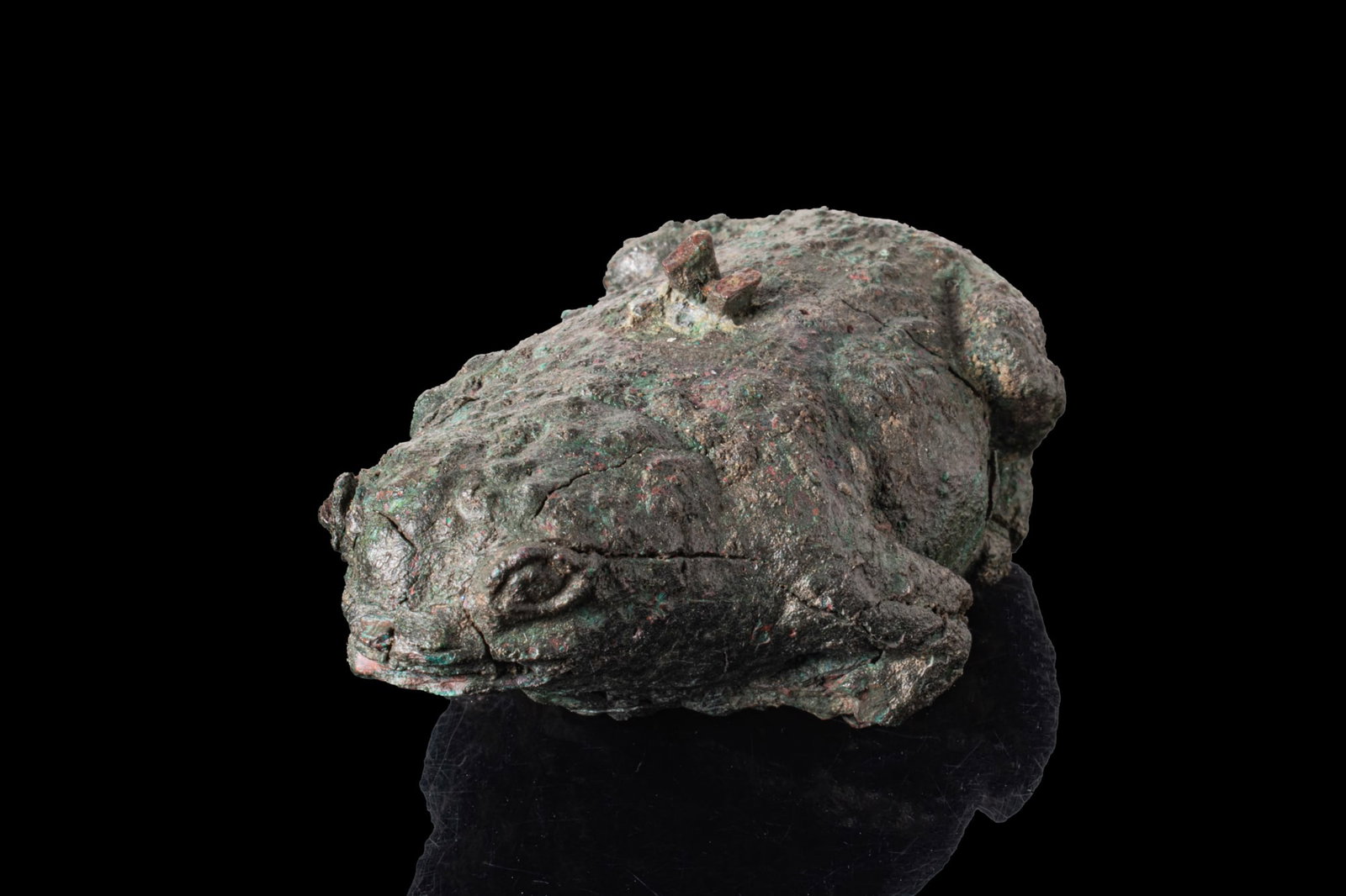 EGYPTIAN BRONZE FROG AMULET: Late Period, Ca. 664 - 332A cast bronze figure of a frog shown in a crouching position with the fore- and hind legs tucked beneath the body, the rounded head with lightly modelled eyes and a short sno