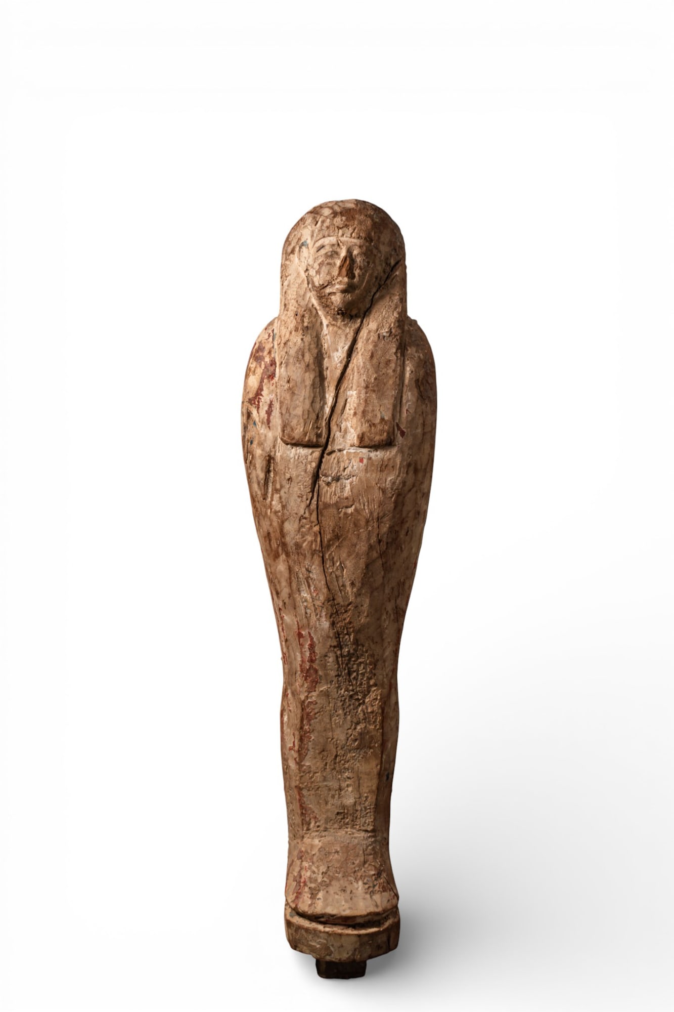EGYPTIAN WOODEN PTAH-SOKAR-OSIRIS: Late Period, Ca. 664 - 332 BC A wooden Ptah-Sokar-Osiris statuette, shown mummiform beneath a tripartite wig, the face modelled in low relief. The body tapers to a rounded base with a projecting tenon