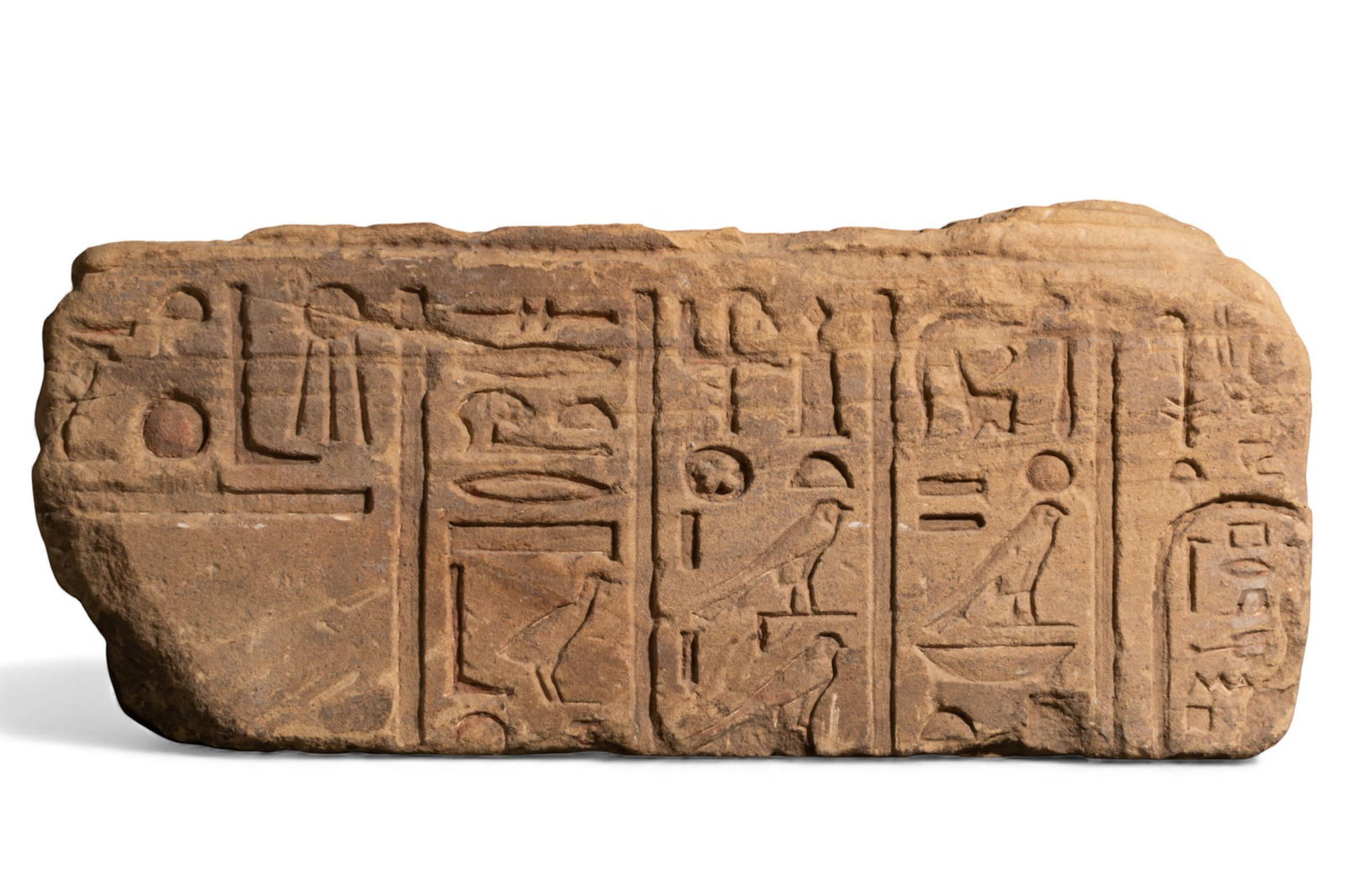 MONUMENTAL EGYPTIAN GRANITE RELIEF WITH HIEROGLYPHIC INSCRIPTION AND CARTHOUCHE: New Kingdom, Ca. 1550 - 1069 BCA rectangular stone relief fragment carved in sunk relief with hieroglyphs arranged in vertical registers separated by incised dividing lines.Size: 250mm x 570mm;