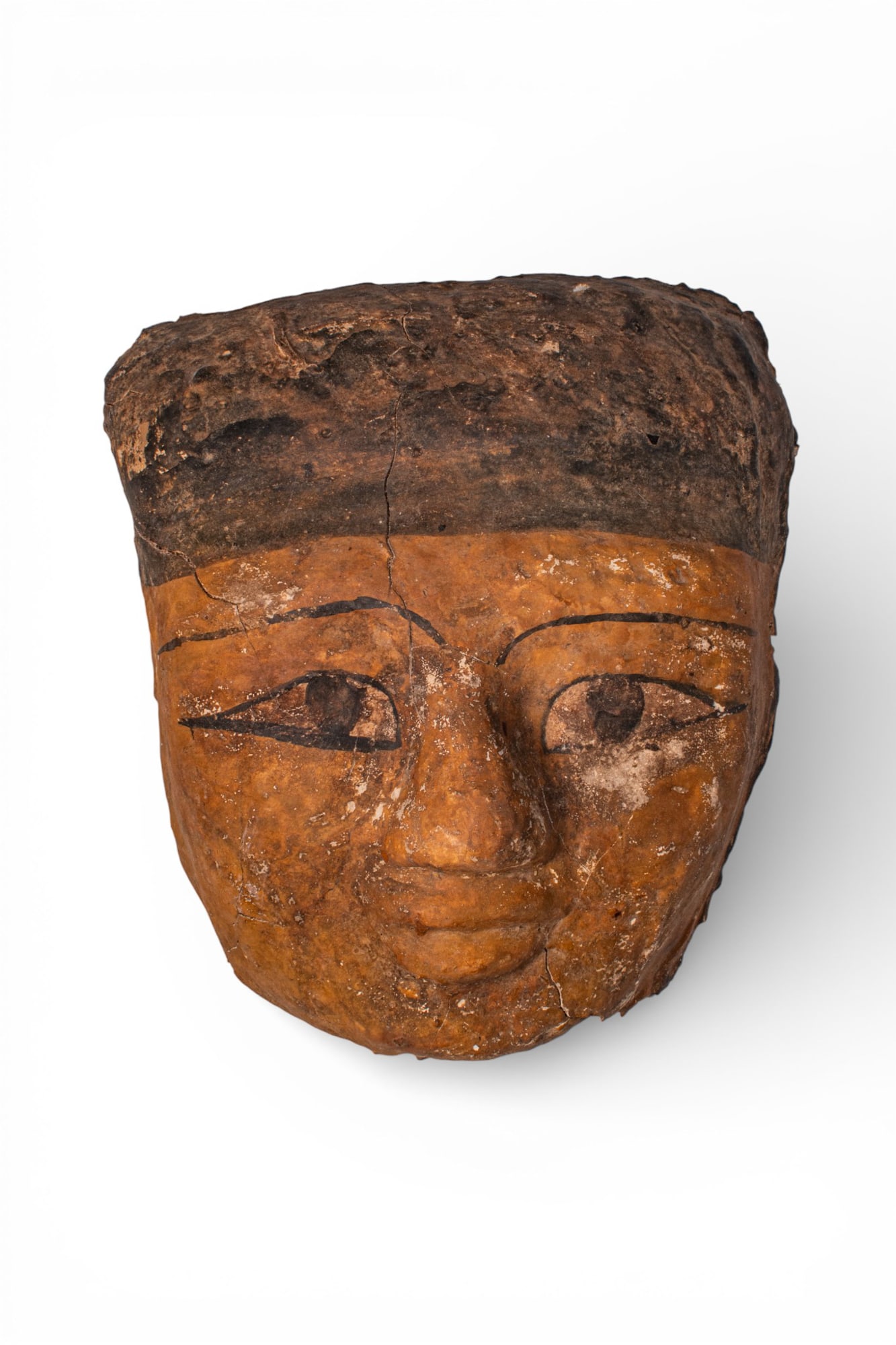 EGYPTIAN PLASTER MUMMY MASK: Late Period, Ca. 664 - 332 BC A plaster mummy mask with elongated eyes painted beneath thin brows, a modelled broad nose, and a closed mouth above a rounded chin. The forehead is framed by a black pai