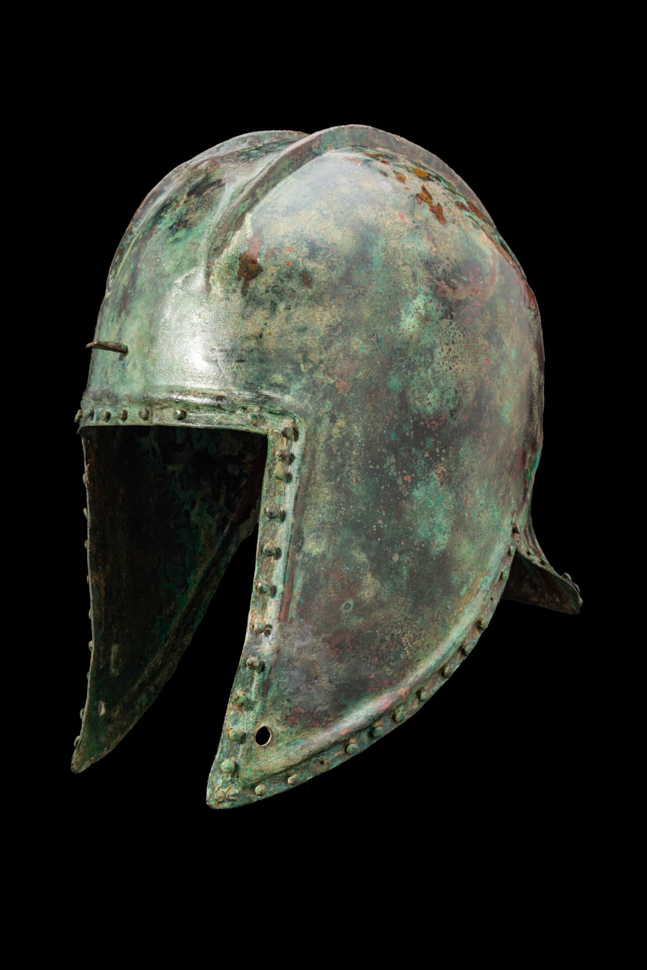 ILLYRIAN BRONZE HELMET: Ca. 500 BC A bronze helmet of Illyrian type with a tall domed skull with two pronounced longitudinal ribs running from the brow to the nape. The front with a broad rectangular opening for the face