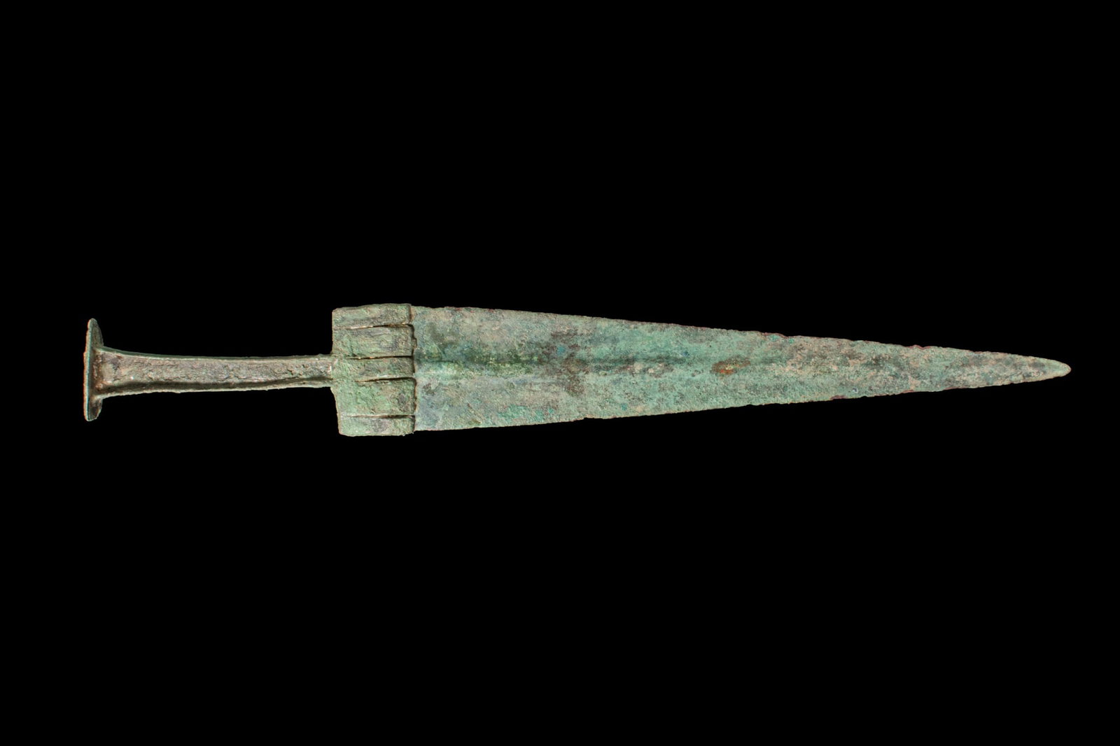 BRONZE AGE / EARLY GREEK PERIOD BRONZE DAGGER: Ca. 1100 - 800 BCA bronze dagger with a double-edged blade and pronounced midrib running to a sharp point, the base with a transverse bar with short ribs, the hilt formed with a slender recessed grip
