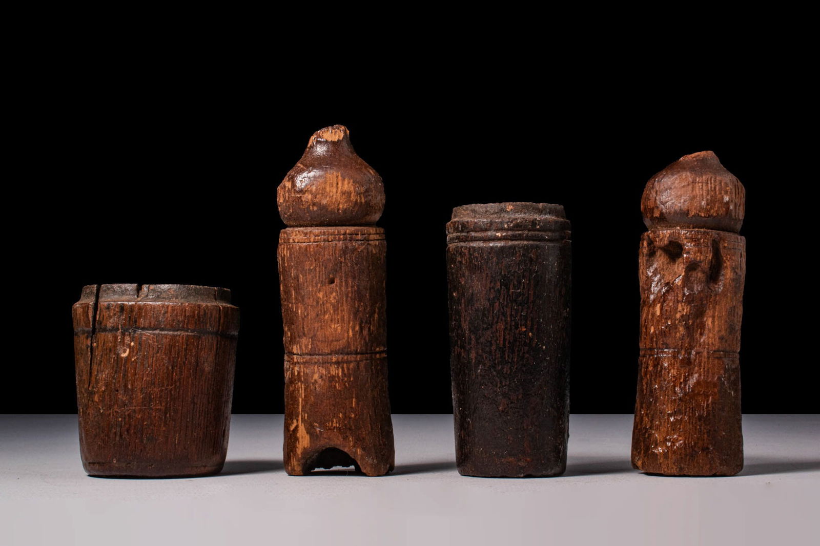 COLLECTION OF EGYPTIAN WOODEN PYXIDES WITH POMEGRANATE LIDS: Ca. 664 - 30 BC. A collection of four wooden pyxides, each carved with a cylindrical body and flat base. Two are fitted with domed lids carved in the form of stylised pomegranates and decorated with